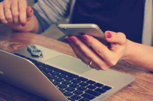 woman on laptop and phone